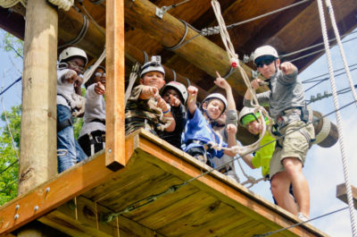 Campers on the high ropes course, where campers cheer each other on as they learn to conquer and overcome.