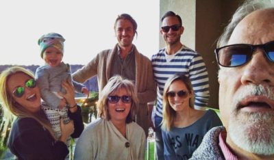 Christy, bottom right, on vacation with her parents, siblings, husband (in stripes) and daughter. 